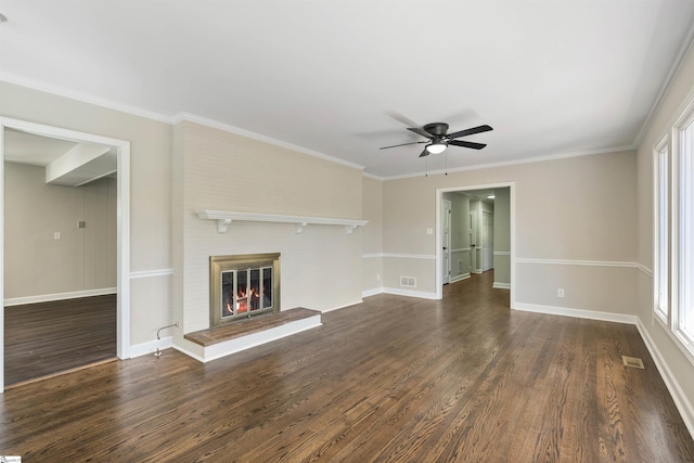 unfurnished living room with visible vents, a fireplace, dark wood-style flooring, and ornamental molding