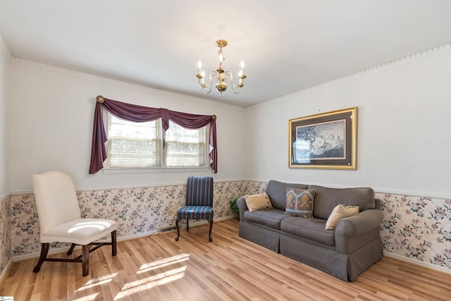 living room featuring light wood-type flooring, baseboards, a notable chandelier, and wallpapered walls