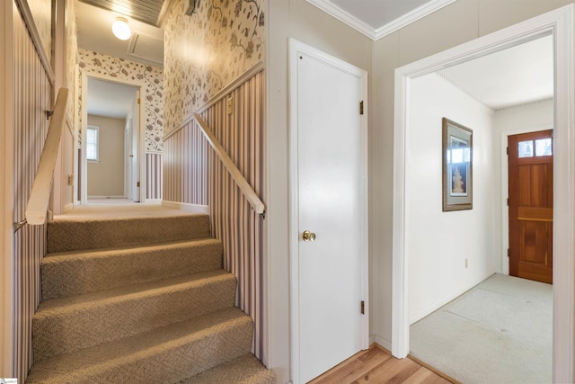 stairway with wallpapered walls, a healthy amount of sunlight, baseboards, and ornamental molding