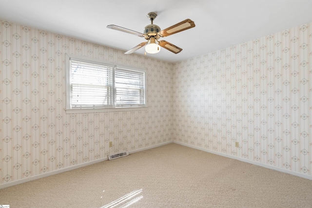 spare room featuring visible vents, baseboards, light colored carpet, and wallpapered walls