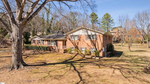 split level home with brick siding and a front yard