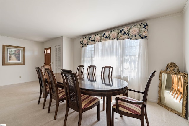 dining space with light colored carpet and baseboards