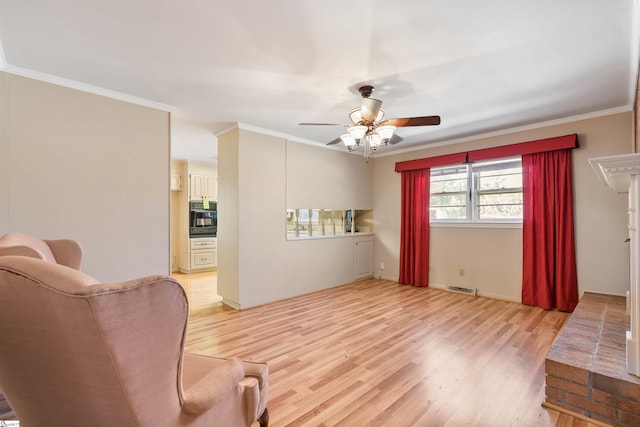 living area featuring visible vents, light wood-style floors, ceiling fan, and crown molding