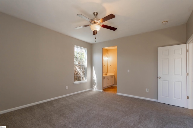 unfurnished bedroom with connected bathroom, baseboards, carpet floors, and ceiling fan