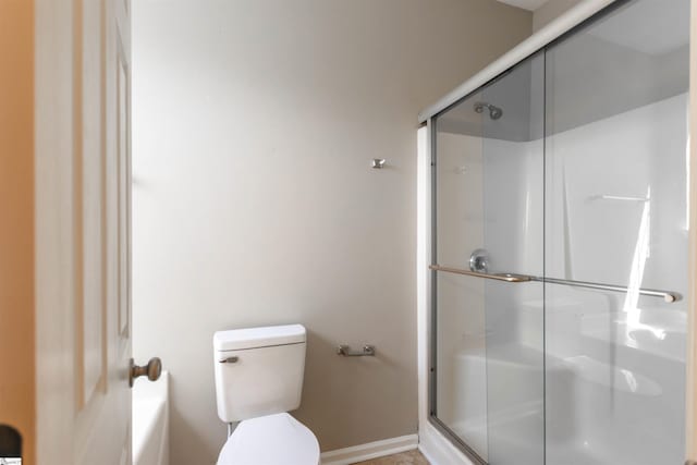 full bathroom featuring a shower with shower door, baseboards, and toilet