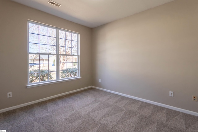 carpeted spare room with visible vents and baseboards