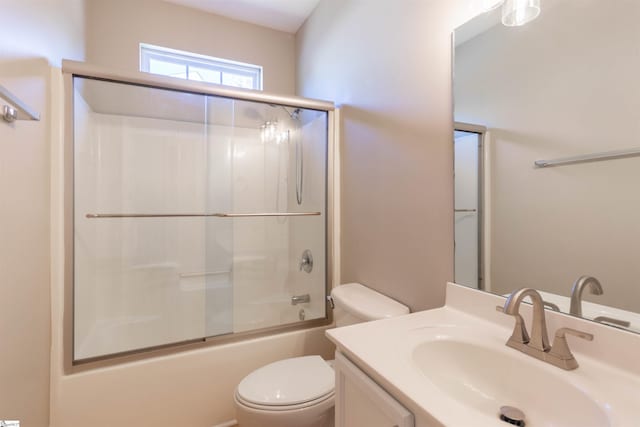 full bathroom with bath / shower combo with glass door, toilet, and vanity