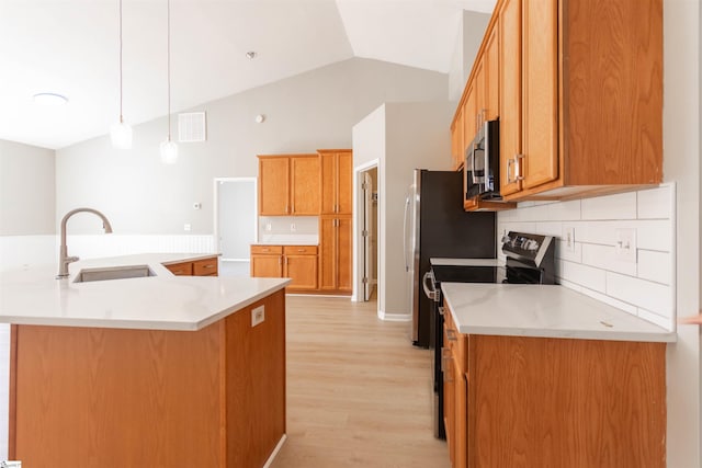 kitchen featuring visible vents, lofted ceiling, light wood-style flooring, appliances with stainless steel finishes, and a sink