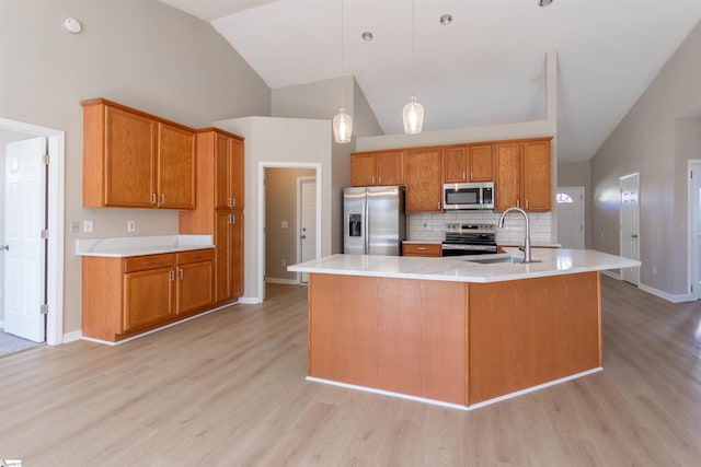 kitchen with a sink, brown cabinets, appliances with stainless steel finishes, and light countertops