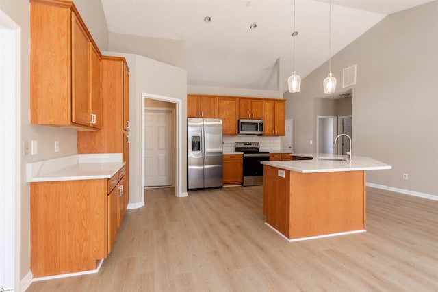 kitchen with visible vents, brown cabinets, a sink, backsplash, and appliances with stainless steel finishes