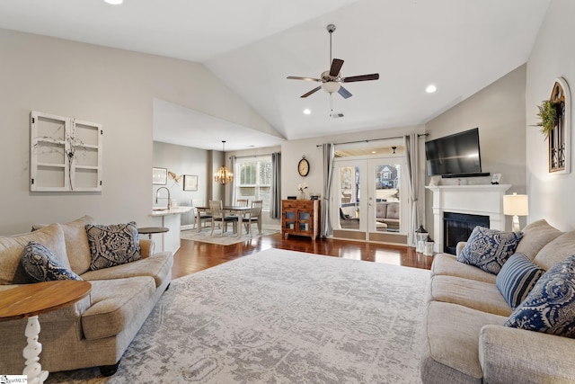 living room featuring a ceiling fan, dark wood finished floors, recessed lighting, vaulted ceiling, and a glass covered fireplace