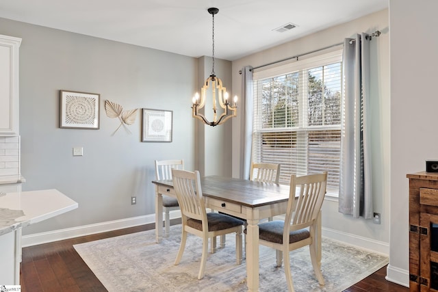 dining space featuring a notable chandelier, baseboards, visible vents, and dark wood-style flooring