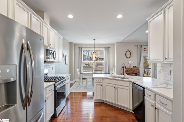 kitchen with dark wood-type flooring, a sink, white cabinetry, appliances with stainless steel finishes, and a peninsula