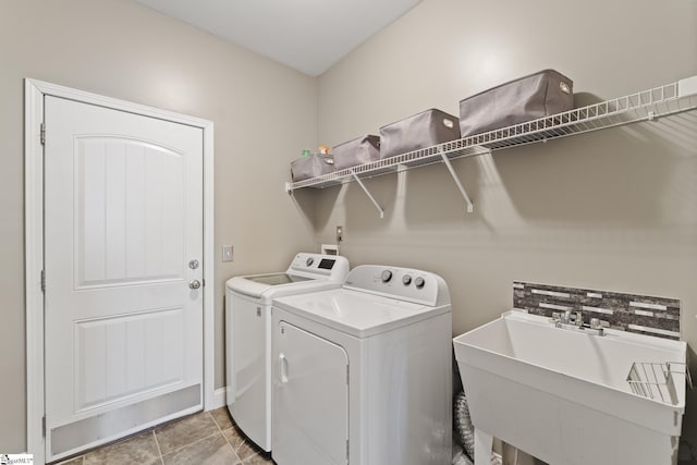 laundry area featuring a sink, light tile patterned floors, laundry area, and washer and clothes dryer