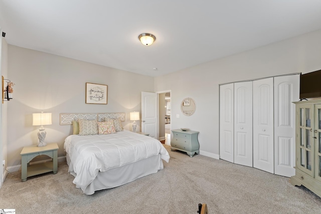 carpeted bedroom with a closet and baseboards