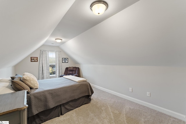 bedroom with lofted ceiling, baseboards, and carpet floors