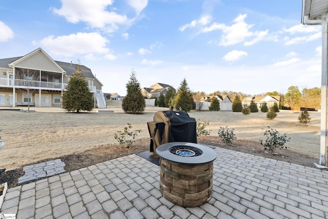 view of patio / terrace with a sunroom and an outdoor fire pit