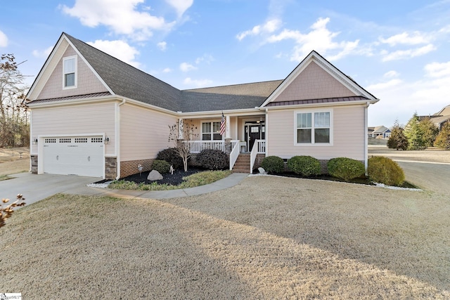 view of front facade featuring metal roof, covered porch, driveway, and a standing seam roof