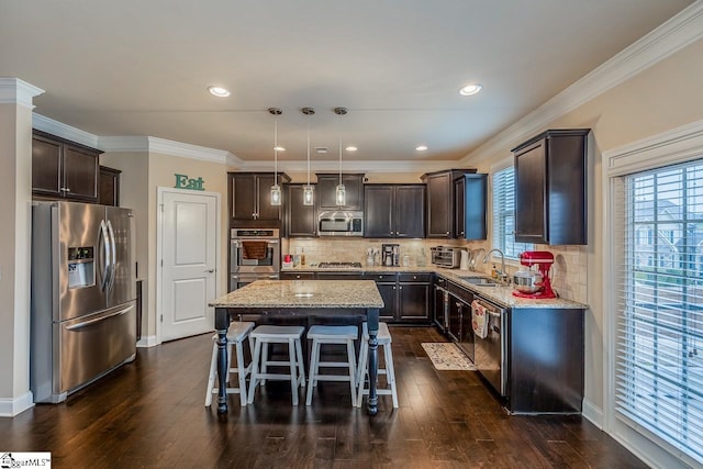 kitchen featuring a center island, dark brown cabinets, appliances with stainless steel finishes, and a sink