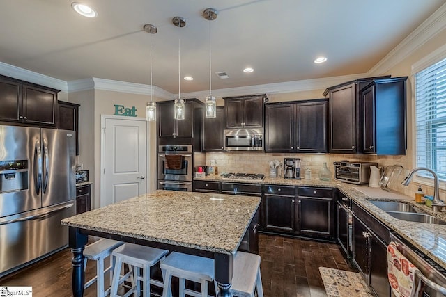 kitchen featuring crown molding, dark wood-style floors, appliances with stainless steel finishes, and a sink