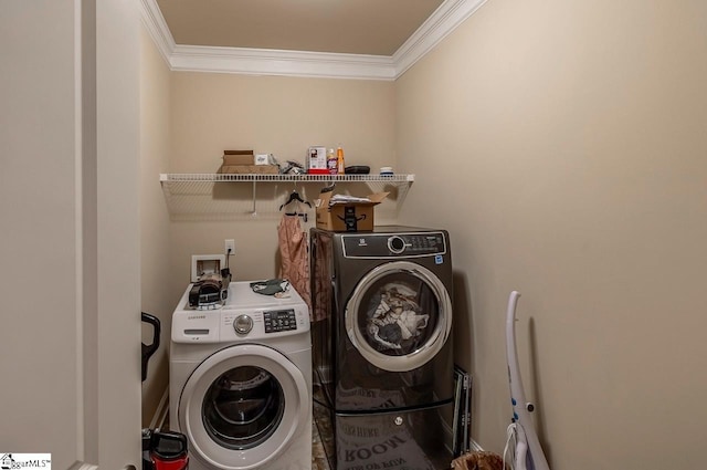 clothes washing area with laundry area, crown molding, and washer and clothes dryer