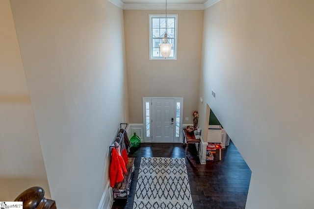 entrance foyer with dark wood-type flooring and crown molding