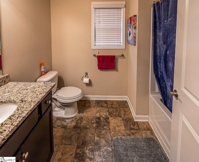 bathroom with toilet, stone finish floor, shower / tub combo, baseboards, and vanity