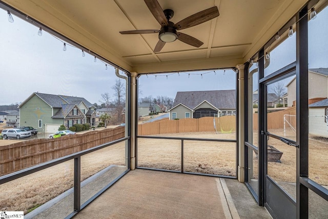 sunroom / solarium featuring a ceiling fan and a residential view