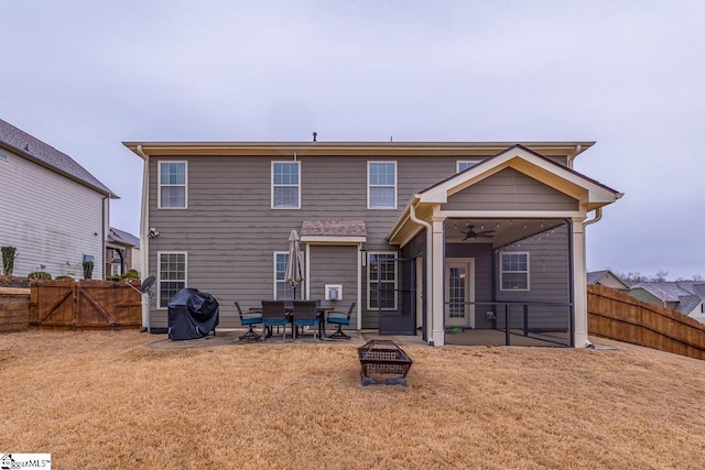 back of house featuring a patio, a gate, a fenced backyard, and a yard