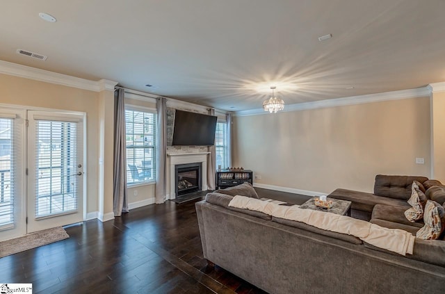 living room featuring a glass covered fireplace, baseboards, dark wood finished floors, and crown molding