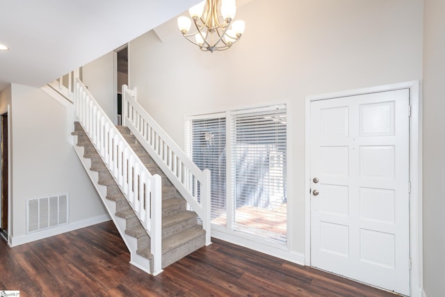 entrance foyer featuring dark wood finished floors, visible vents, stairs, and baseboards