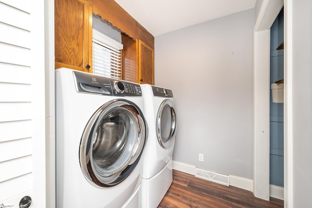 laundry area with washing machine and clothes dryer, cabinet space, dark wood finished floors, and baseboards