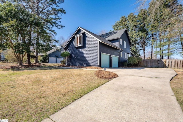 view of home's exterior featuring a lawn, driveway, and fence