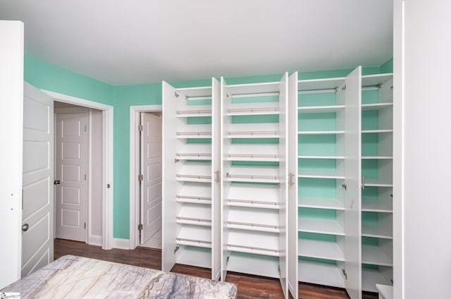 unfurnished bedroom featuring a closet, baseboards, and wood finished floors