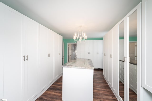 kitchen featuring dark wood-type flooring, white cabinets, a notable chandelier, and a kitchen island