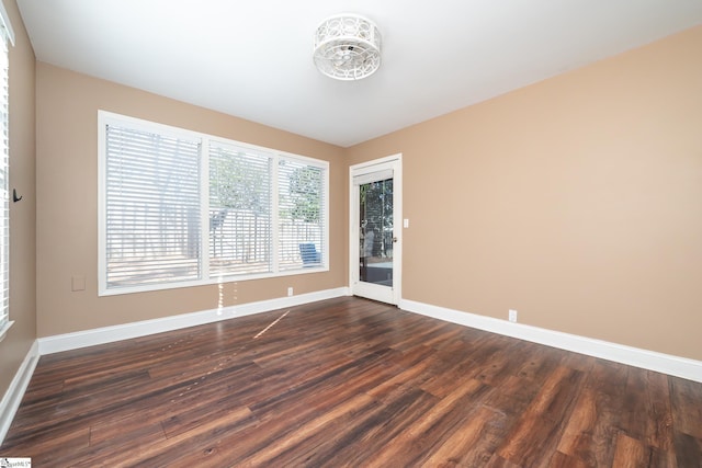 spare room with dark wood-style floors and baseboards