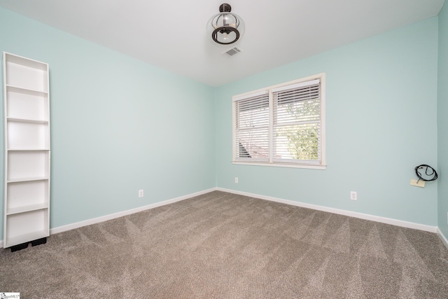 carpeted empty room with visible vents and baseboards