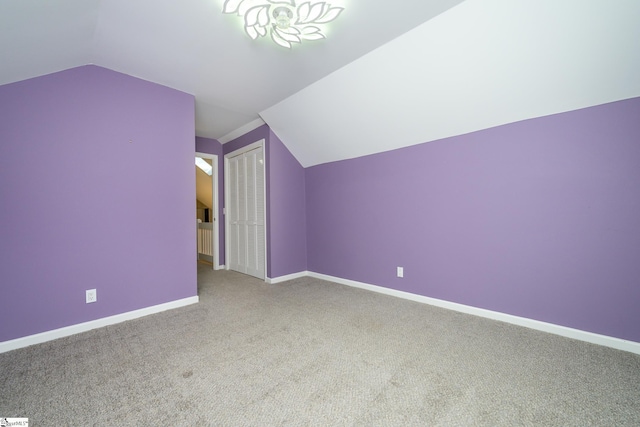 additional living space featuring vaulted ceiling, carpet, and baseboards