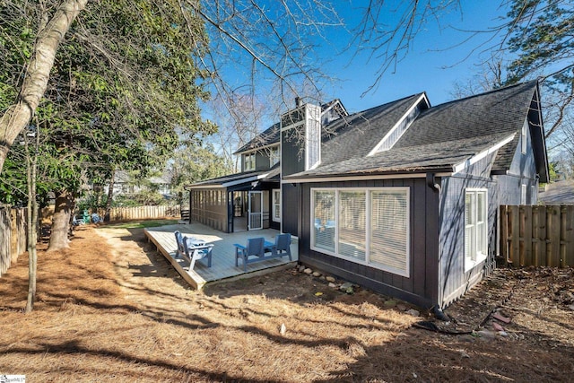 rear view of property with a fenced backyard, a chimney, roof with shingles, and a wooden deck