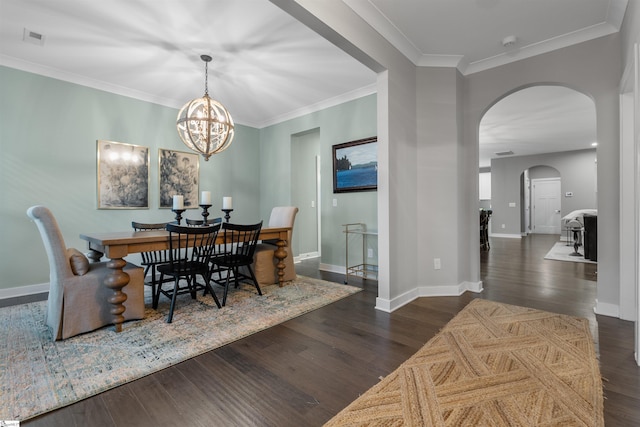 dining room featuring crown molding, wood finished floors, arched walkways, and baseboards