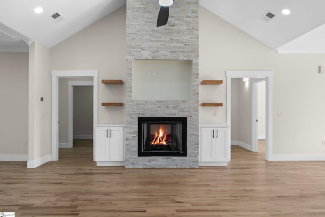 unfurnished living room with baseboards, a fireplace, visible vents, and light wood-type flooring