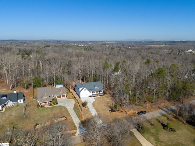 birds eye view of property featuring a forest view