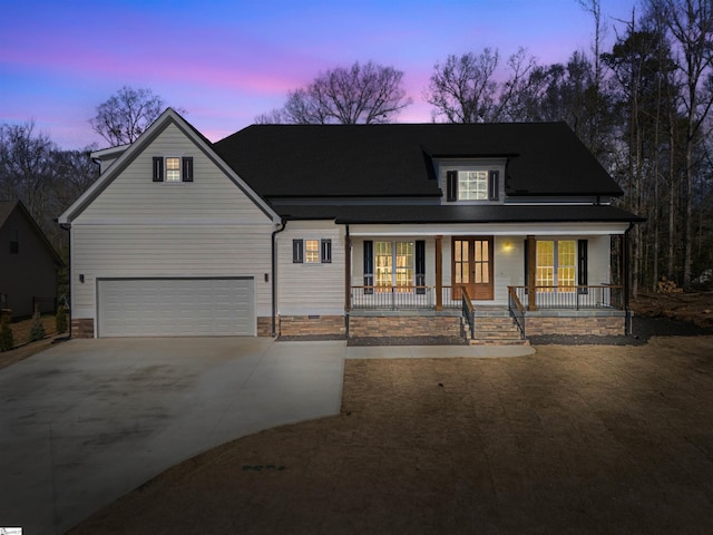 view of front of home with a porch, driveway, and a garage