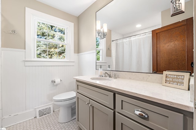 bathroom featuring tile patterned floors, visible vents, toilet, wainscoting, and vanity