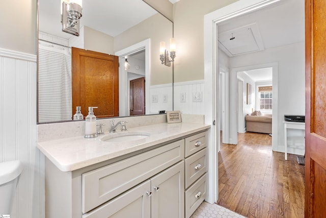 bathroom with vanity, wood finished floors, and wainscoting