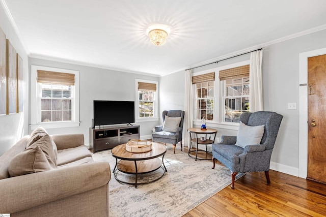 living room featuring light wood-style floors, baseboards, and ornamental molding