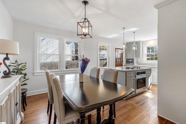 dining space with baseboards and wood finished floors