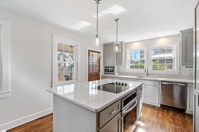 kitchen with a sink, stainless steel appliances, dark wood-type flooring, and a center island