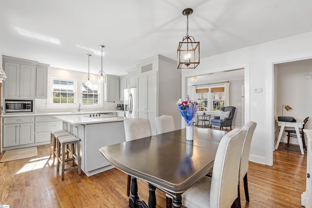 dining area with visible vents, plenty of natural light, light wood-style floors, and baseboards