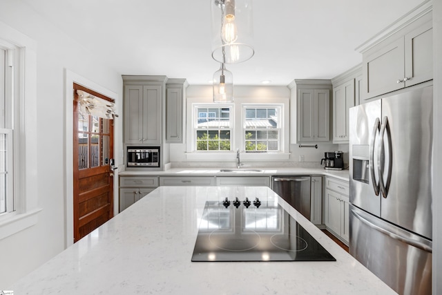 kitchen featuring a sink, appliances with stainless steel finishes, gray cabinets, and a healthy amount of sunlight